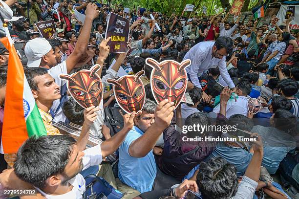 Cockroach Janta Party supporter holds a cockroach mask during a protest over alleged irregularities in the country's major examinations on June 6,...