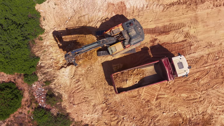 https://media.gettyimages.com/id/2279730795/video/excavator-loading-dump-truck-at-construction-site-from-above.jpg?b=1&s=640x640&k=20&c=A3p6--PK67ih_2tgoRdWsAI0PE18KswObTsa64ftpOg=