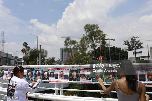 Families and activists from the 'Colectivo Luz de Esperanza Jalisco' place modified designs of traditional collectible football stickers, where...