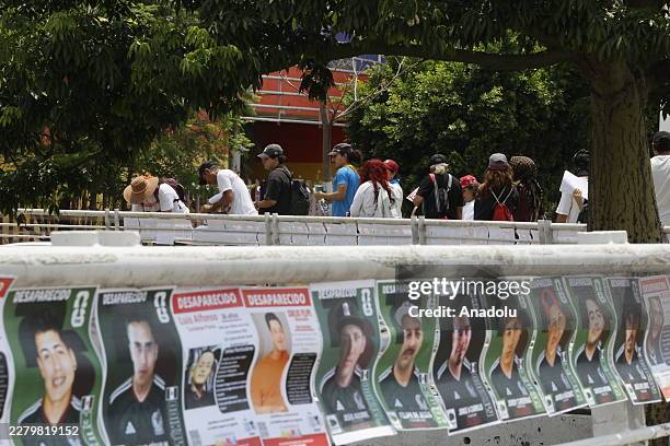 Families and activists from the 'Colectivo Luz de Esperanza Jalisco' place modified designs of traditional collectible football stickers, where...