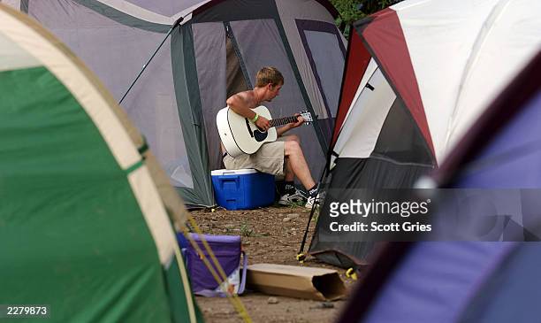 Roderick Plymale of Elizabeth, Kentucky plays guitar in the campground at the site of Woodstock '99 in Rome, New York. Woodstock '99 30th Anniversary...