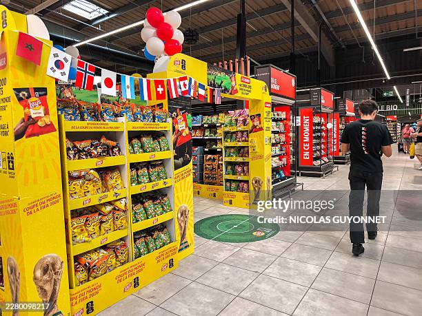 Young man walks in front of a special stand of aperitif cakes and chips from the Lay brand, official sponsor of the FIFA Football World Cup, with...