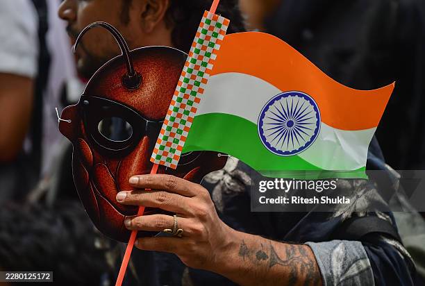 Supporter of CJP holds a cockroach mask and the Indian national flag during a protest demanding the resignation of the Education Minister over...
