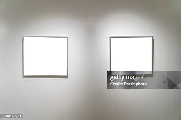 two blank square frames mockup on gallery wall under spotlights - gallery mockup stock pictures, royalty-free photos & images