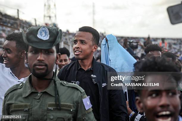 Somali international referee Omar Abdulkadir Artan reacts as he is welcomed by supporters ahead of a solidarity football match after returning to...