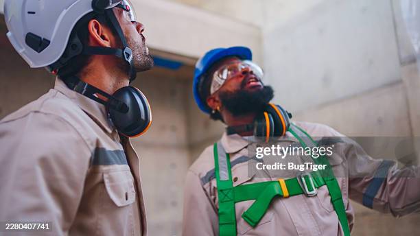 two construction workers working together while visiting a new building. - instructions stock pictures, royalty-free photos & images
