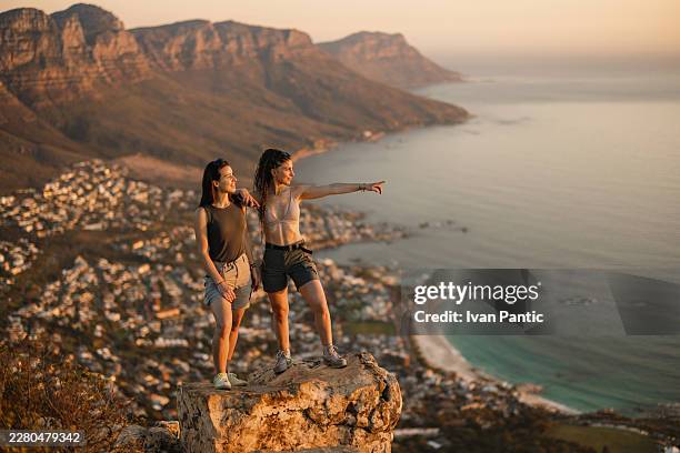 friends hiking at sunset in cape town - camps bay stock pictures, royalty-free photos & images