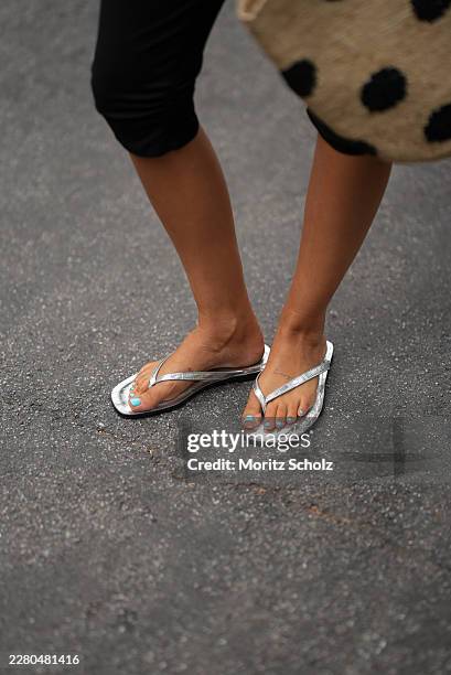 Julia Kammerer is seen wearing black stretch capri trousers with a cropped silhouette from ASOS; metallic silver thong sandals from H&M; a natural...