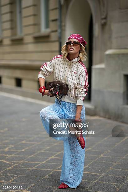 Julia Kammerer is seen wearing a cream track jacket with pink pinstripes, a high stand collar, zip front closure and three stripe sleeve details from...