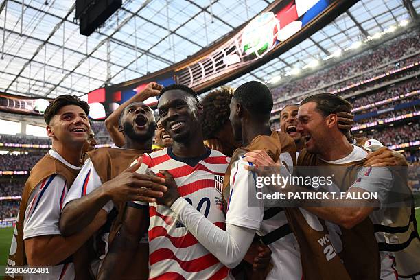Forward Folarin Balogun celebrates with teammates after scoring his team's third goal during the 2026 World Cup Group D football match between USA...