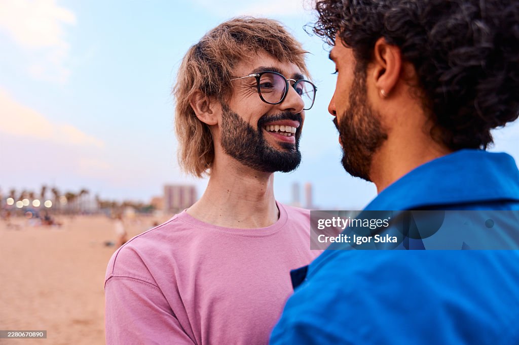Coppia gay che si gode un momento d'amore sulla spiaggia al tramonto