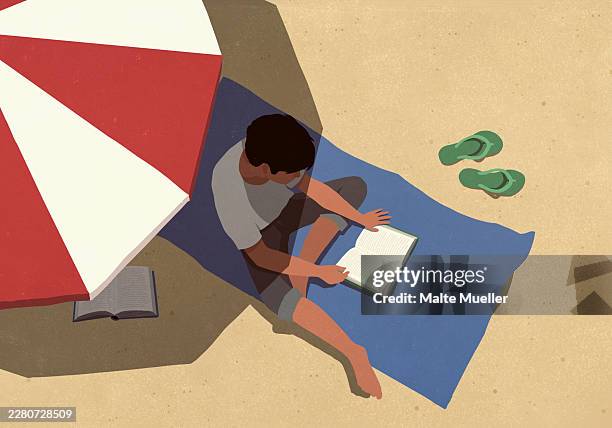 high angle view young man reading book in shade under striped umbrella on sunny summer beach - summer reading stock illustrations
