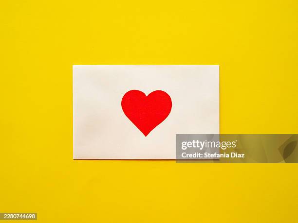 white envelope with red heart on bright yellow background - love letter stock pictures, royalty-free photos & images