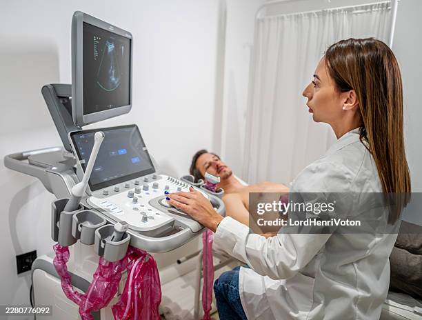 arzt führt herz-echokardiogramm beim männlichen patienten durch - echokardiogramm stock-fotos und bilder