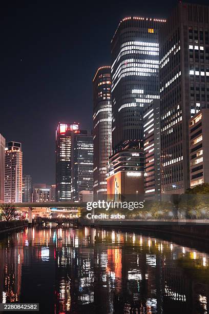 modern city skyscrapers reflection on river at night, osaka city at night, japan - osaka prefecture stock pictures, royalty-free photos & images