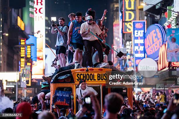 New York Knicks fans climb on buses as they celebrate after they win the NBA Finals in Times Square on June 14, 2026 in New York City. The New York...