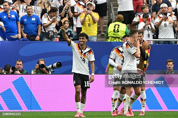 Germany's defender Nathaniel Brown celebrates with teammates after scoring his team's fifth goal during the 2026 World Cup Group E football match...