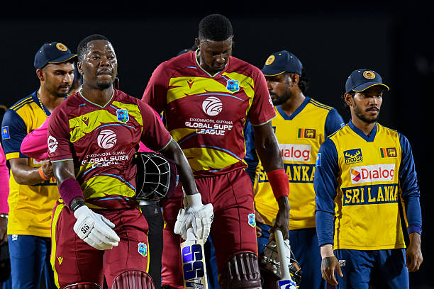 Sherfane Rutherford and Jason Holder of West Indies walk off the field after winning the third Twenty20 international cricket match between West...