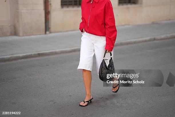 Lina Uhrig is seen wearing a red cotton cropped jacket with a shirt collar, front zip closure, long sleeves, relaxed oversized silhouette and minimal...