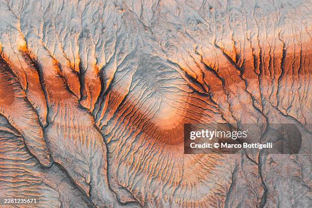 aerial abstract of eroded desert ridges in orange and grey, mangystau region, western kazakhstan - kasachstan stock-fotos und bilder