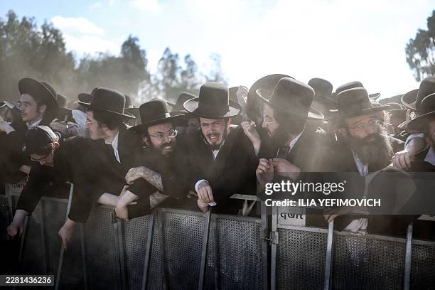 Ultra-Orthodox Jews react as they stand behind a barrier during a protest against military conscription outside Bet Lid military prison in Kfar Yona...