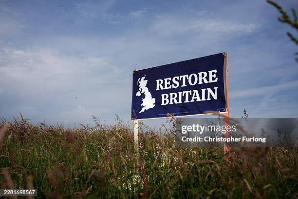 Restore Britain party by-election placard stands in a field on June 15, 2026 in Ashton-in-Makerfield, England. The Makerfield by-election will take...