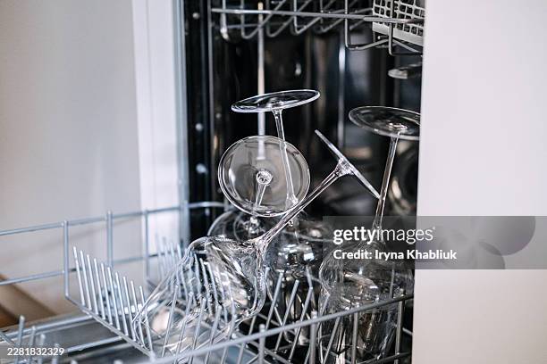 delicate wine glasses sit upside down inside open dishwasher rack. cleaning fragile crystal stemware, spotless glass shine, preventing cloudy glassware, dishwasher wine glass rack. - crystal glassware stock pictures, royalty-free photos & images