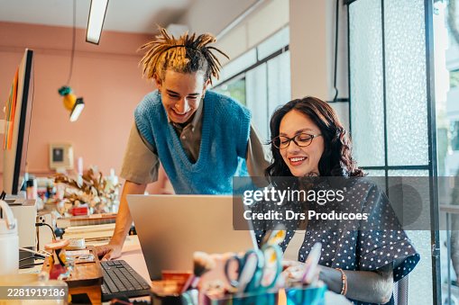 Zwei junge Gen-Z-Personen, die gemeinsam an einem Projekt in einem modernen Büro arbeiten. Zwei junge Gen-Z-Personen, die gemeinsam an einem Projekt in einem modernen Büro arbeiten.