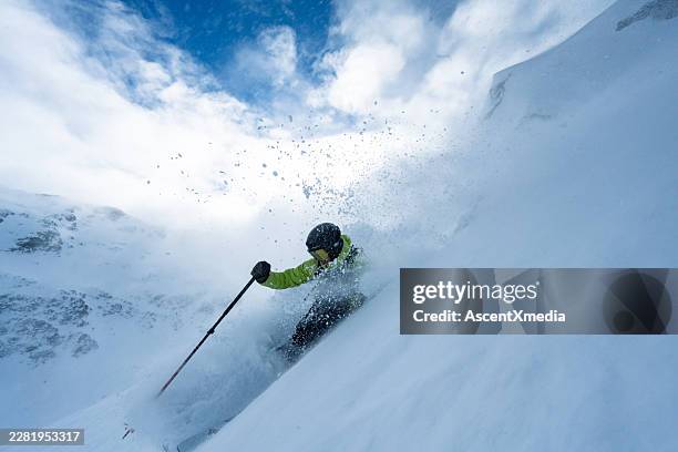 backcountry skier descends slope through fresh powder snow - esqui e snowboard imagens e fotografias de stock