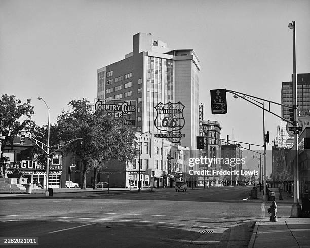 Large 'Country Club Beer' and 'Phillips 66' signs above Broadway in downtown Denver, Denver County, Colorado, circa 1960.