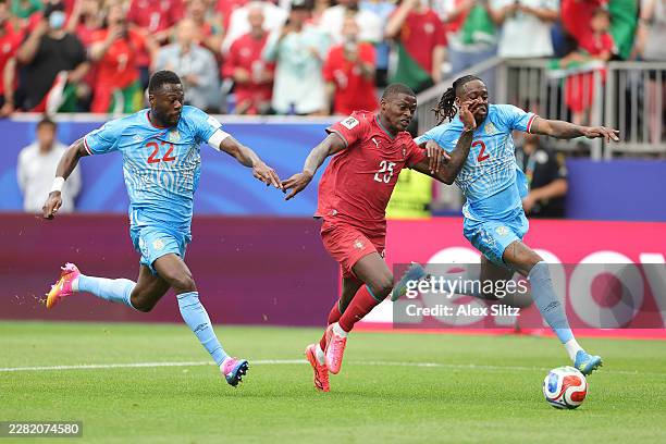 Nuno Mendes of Portugal is challenged by Chancel Mbemba and Aaron Wan-Bissaka of Congo DR during the FIFA World Cup 2026 Group K match between...