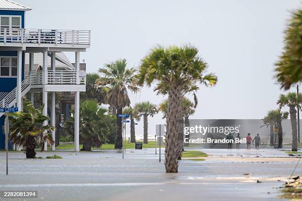 People walk through a flooded neighborhood after Tropical Storm Arthur made landfall on June 17, 2026 in Freeport, Texas. A Tropical Storm Watch has...