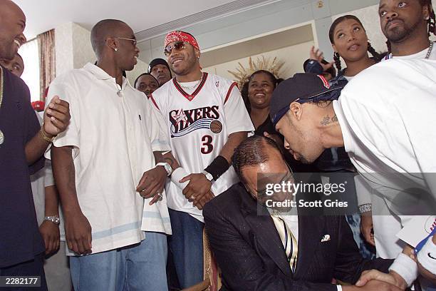 Louis Farrakhan talks with Red Man, while Sean 'Puffy' Combs, LL Cool J, Jermaine Dupri, Queen Latifah, and Sister Souljah talk in the background,...