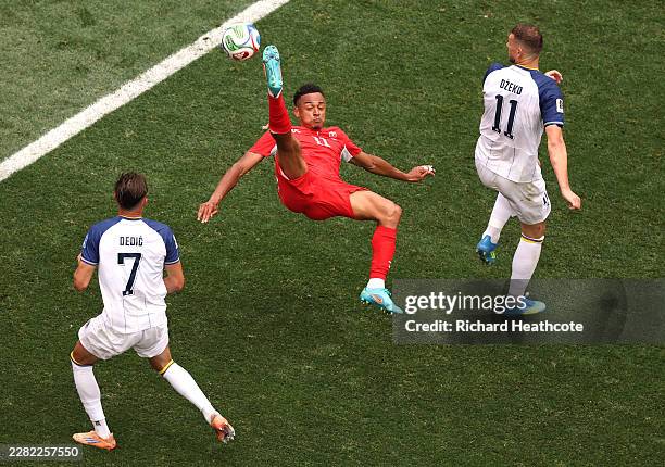 Dan Ndoye of Switzerland attempts an overhead kick under pressure from Amar Dedic and Edin Dzeko of Bosnia and Herzegovina during the FIFA World Cup...