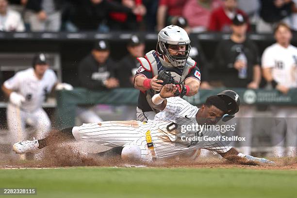 Luisangel Acuña of the Chicago White Sox is tagged out at home plate by Austin Hedges of the Cleveland Guardians during the third inning at Rate...