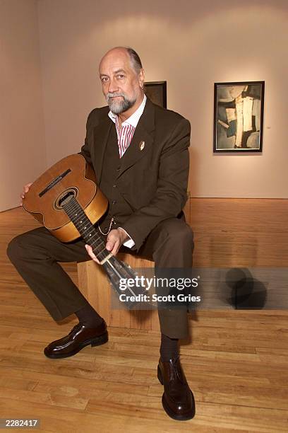 Mick Fleetwood holding Stuart Sutcliffe's first guitar at a press conference to unveil the artwork and memoriblia of Mr. Sutcliffe, the "5th Beatle",...