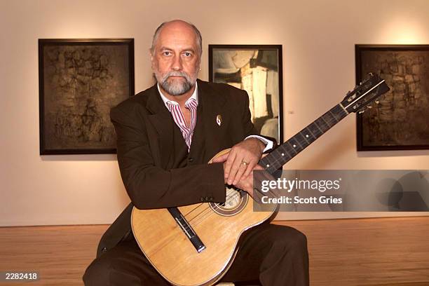Mick Fleetwood holding Stuart Sutcliffe's first guitar at a press conference to unveil the artwork and memoriblia of Mr. Sutcliffe, the "5th Beatle",...