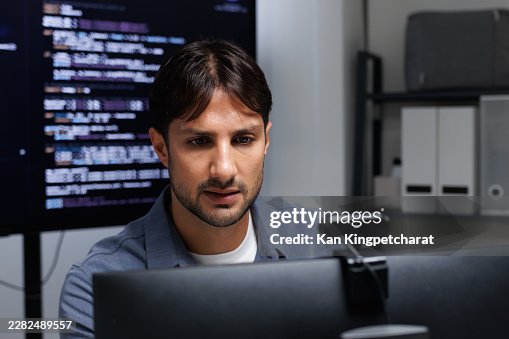 Asian Male Software Developer Concentrating on Program Logic During a Focused Work Session. Asian Male Software Developer Concentrating on Program Logic During a Focused Work Session.