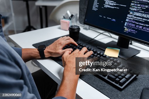 Male Software Developer Writing Code and Reviewing Program Logic on Screen During Daily Office Work. Male Software Developer Writing Code and Reviewing Program Logic on Screen During Daily Office Work.