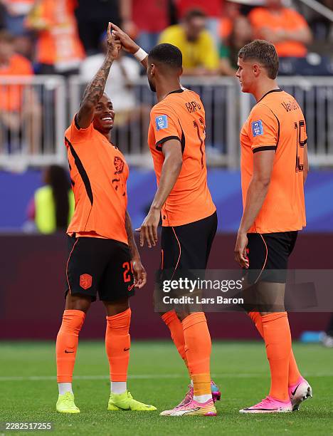 Cody Gakpo of the Netherlands celebrates with teammates Crysencio Summerville and Micky van de Ven after scoring his team's third goal during the...