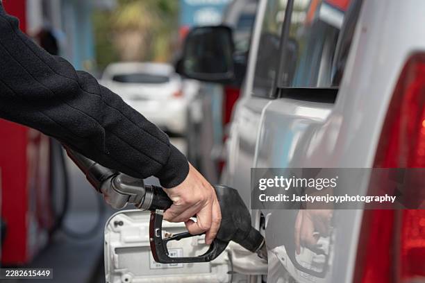 close-up of a man filling up a vehicle with diesel - crise pétrolière photos et images de collection