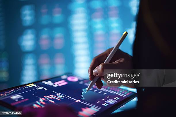 hand using stylus on tablet showing stock market charts and crypto finance data - digital currency stock pictures, royalty-free photos & images