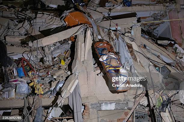 Rescue personnel transport an elderly person on a stretcher after the individual was rescued from the rubble of a collapsed building in the San...