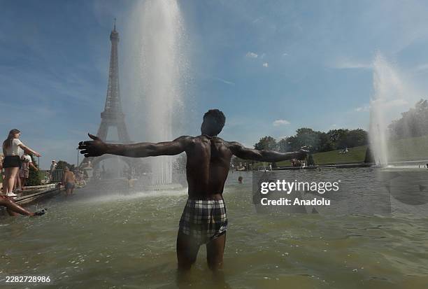 People cool off in the fountains of the Trocadero Gardens, with the Eiffel Tower in the background, in Paris, France, on June 25, 2026.