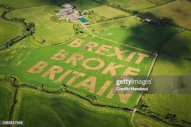 An aerial view as activists from the Campaign group Led By Donkeys use a tractor and harrow to carve BREXIT BROKE BRITAIN in giant letters on June...