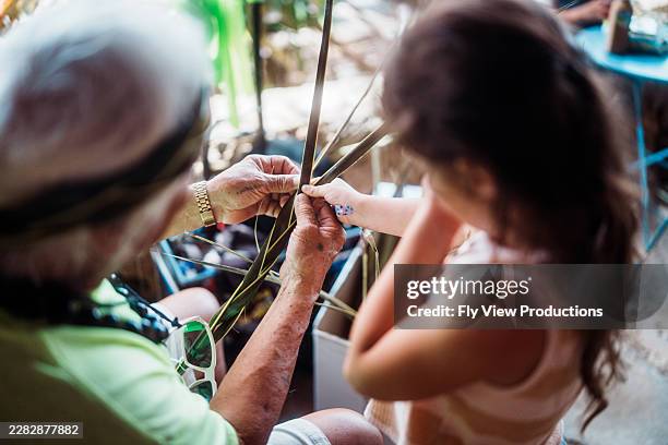 educator demonstrating weaving techniques to young girl - braided stock pictures, royalty-free photos & images