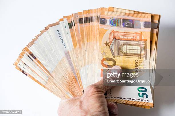 large fan of fifty-euro banknotes held tightly in a human hand - allowance stock pictures, royalty-free photos & images