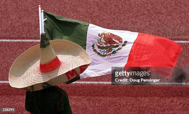 MEXICAN FAN IN SOMBRERO HAT WAVING THE NATIONAL FLAG OF MEXICO WATCHES THE NATIONAL SOCCER TEAM IN TRAINING FOR THE UPCOMING WORLD CUP AT THEIR...