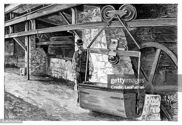 operating an aerial conveyor system a worker stands by a large metal bucket at a loading station - mining africa stock illustrations