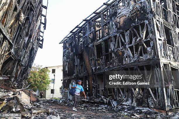 Person walks in front of burned-down buildings at Catia La Mar after a magnitude 7.2 earthquake struck Venezuela and other regions in the Caribbean...